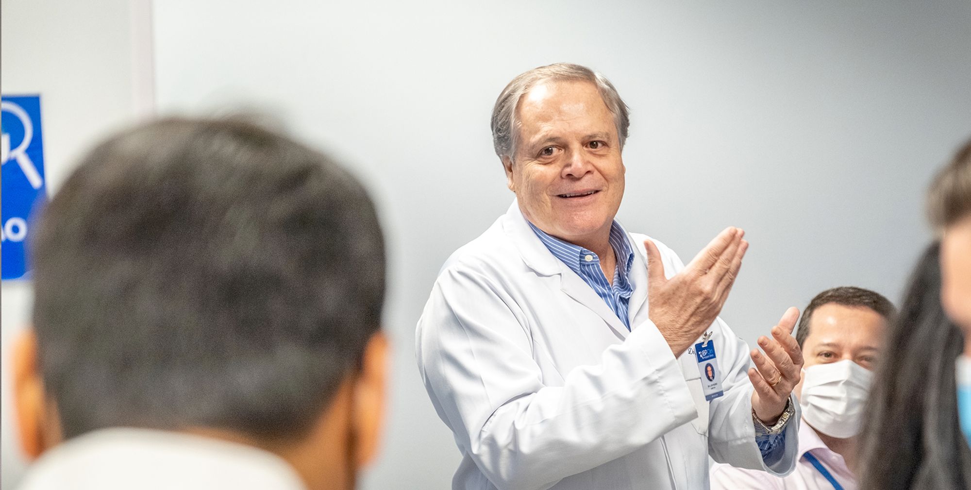 médico palestrando para um grupo de pessoas