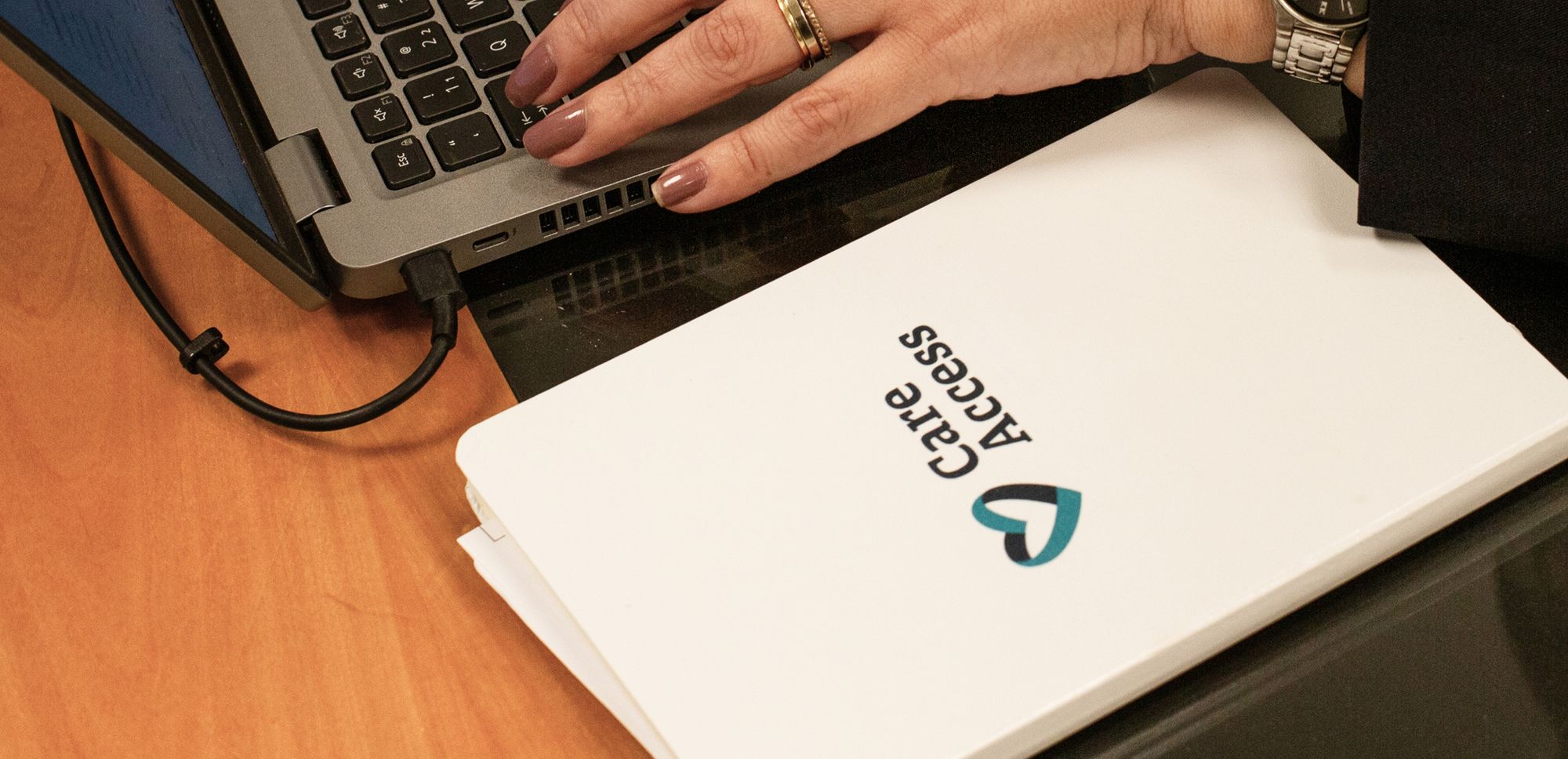 cropped image of a Care Access notebook and employee