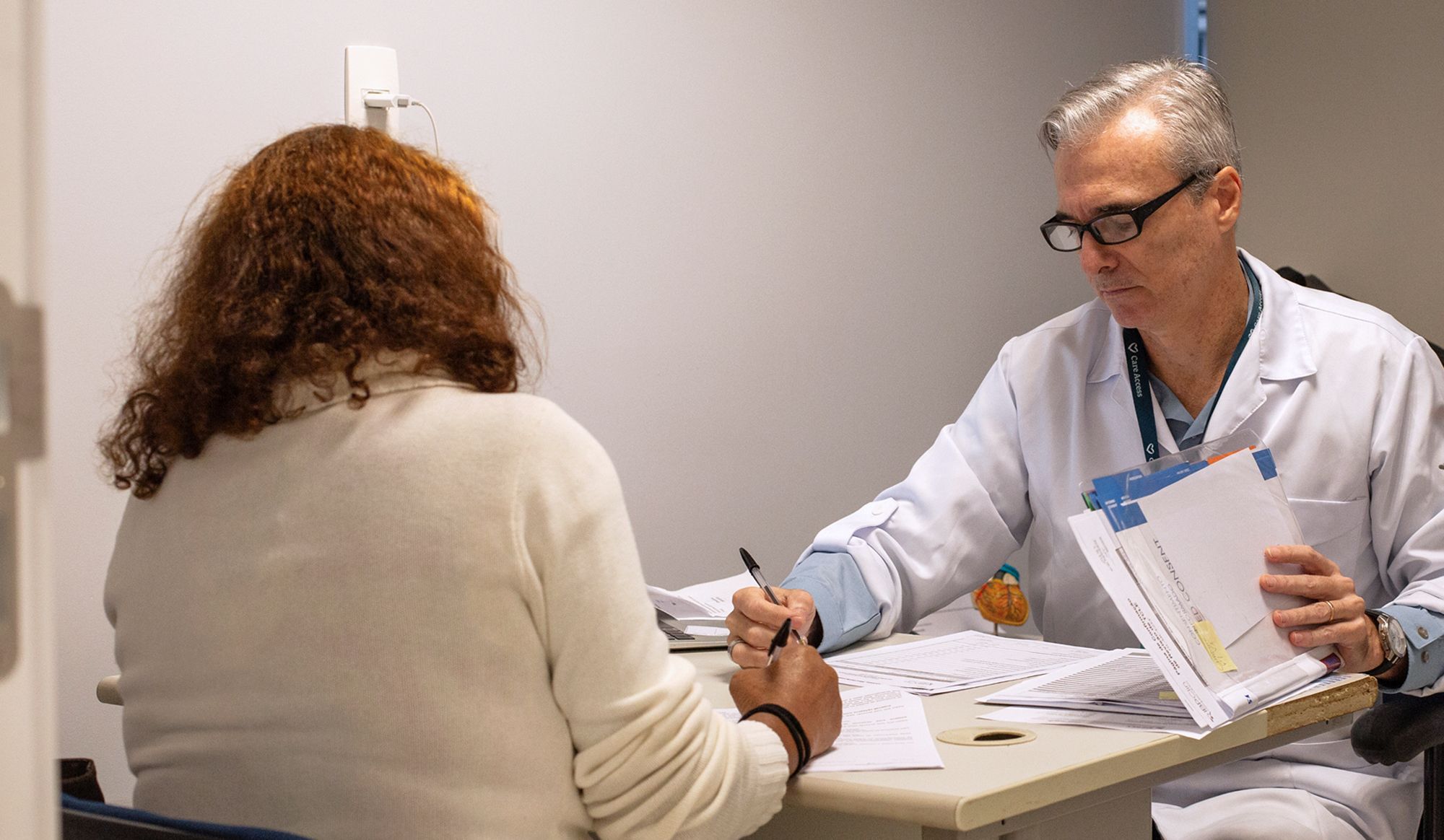 médico analisando documentos com paciente